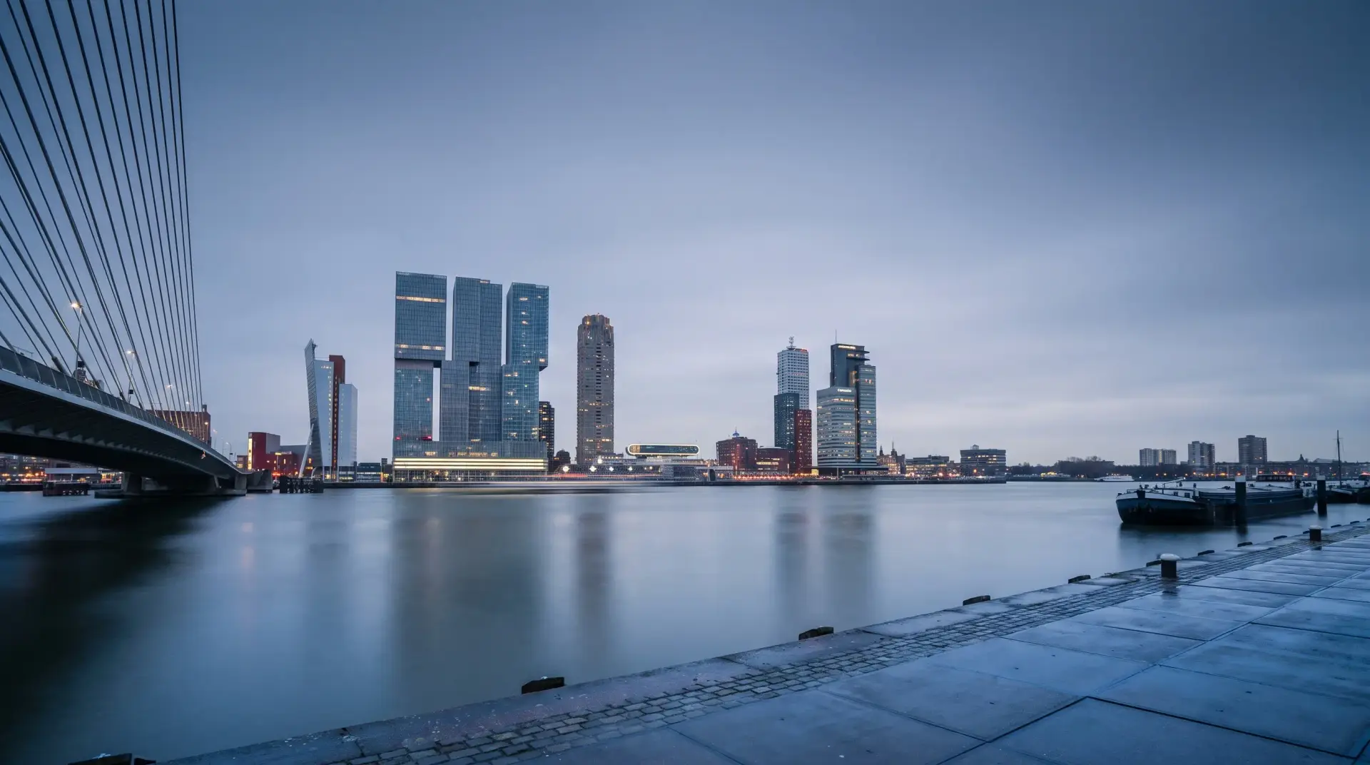 De skyline van Rotterdam aan de Nieuwe Maas tijdens het blauwe uur