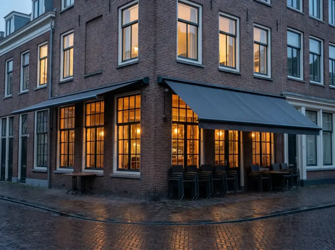 Nederlands hoekpand met horecagelegenheid en woningen erboven in de avondschemering